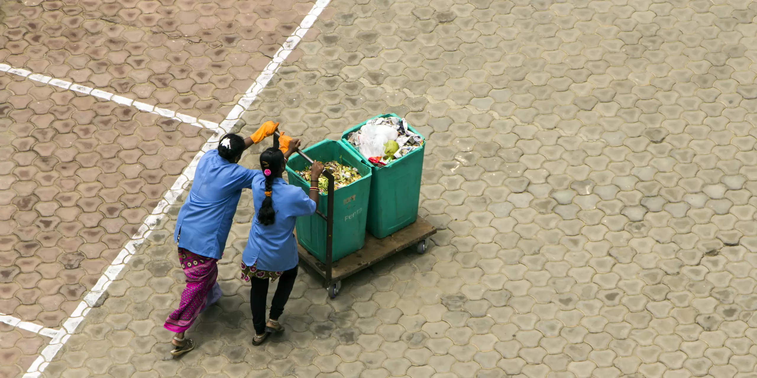 Women push a cart containing segregated garbage in an apartment complex in Bangalore, India.